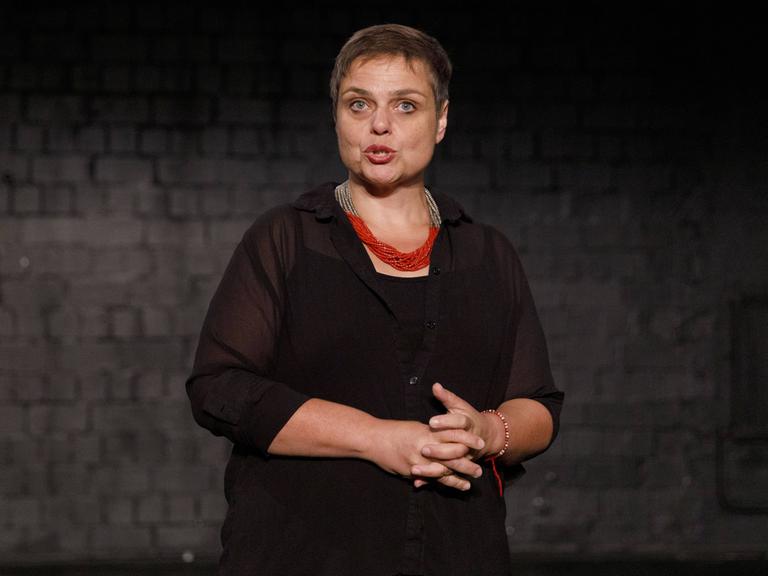 Bettina Montazem beim Pressetermin zu ""Das Sherlock Musical" im Urania Theater in Köln Ehrenfeld in dunkler Kleidung vor dunklem Hintergrund. 