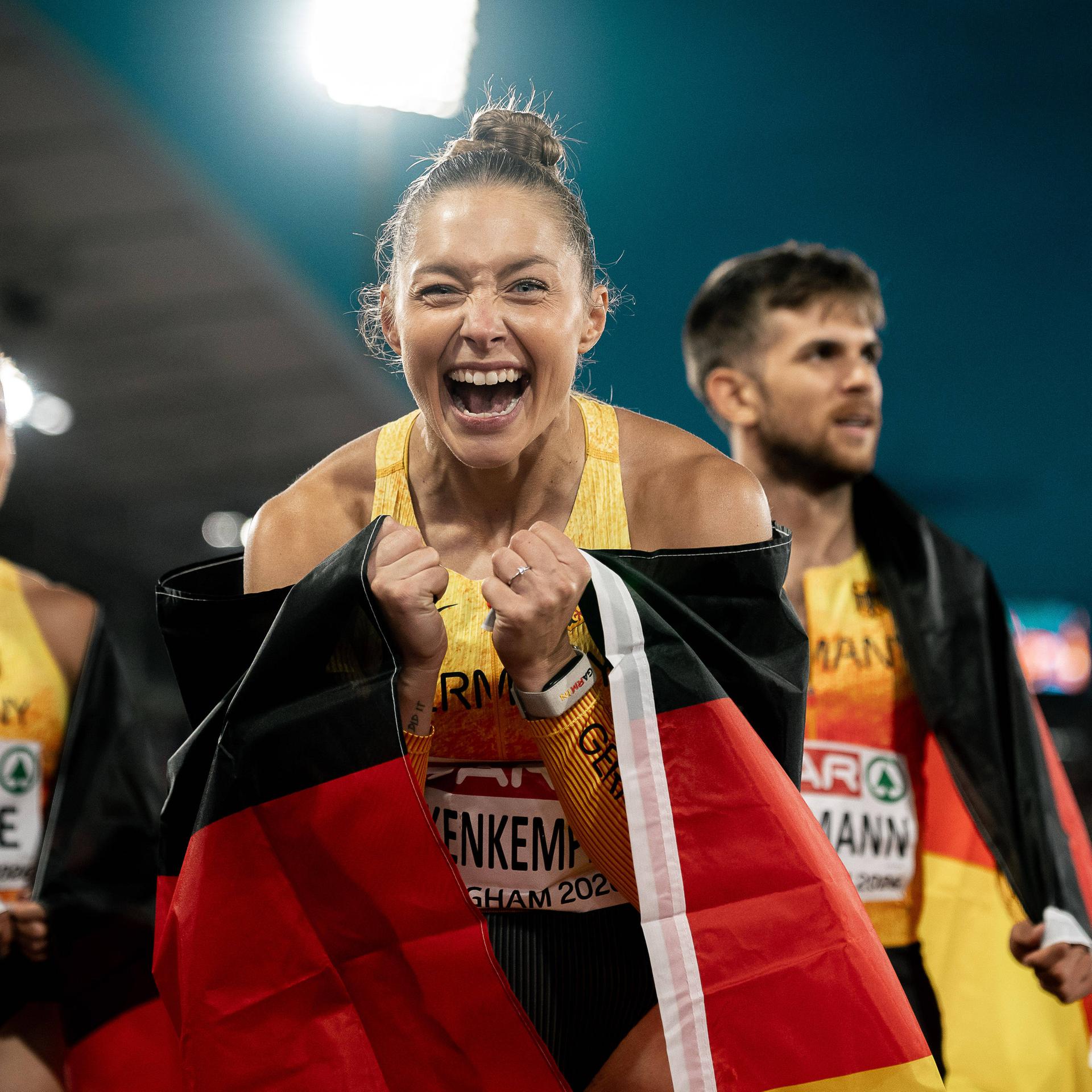 Kevin Kranz, Heiko Gussmann sowie Rebekka Haase und Gina Lückenkemper jubeln nach ihrer Silbermedaille mit einer Deutschlandflagge.