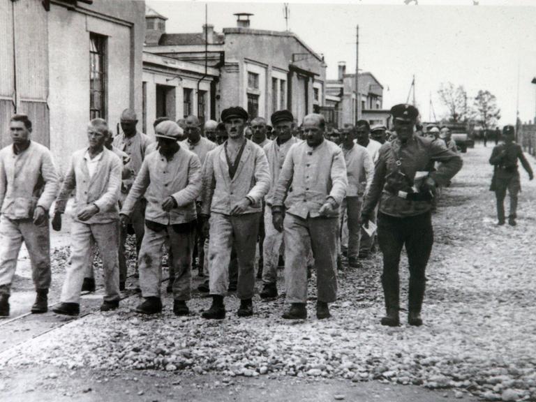 Gefangene marschieren im Konzentrationslager von Dachau  