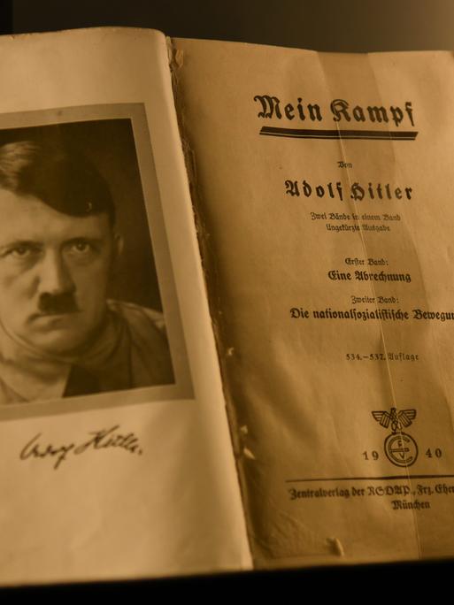 Das Bild zeigt das aufgeschlagene Buch "Mein Kampf" von Adolf Hitler