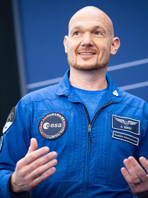 Astronaut Alexander Gerst im blauen Overall gestikuliert lächelnd bei der Esa-Ministerratstagung. Astronaut Alexander Gerst im blauen Overall gestikuliert lächelnd bei der Esa-Ministerratstagung.