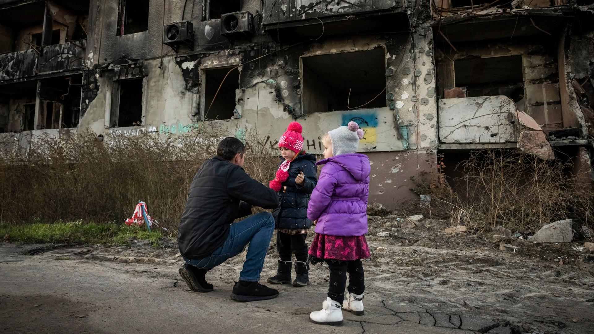 Mann und Kinder in einem zerstörten Haus in Borodyanska in der Region Kiew in der Ukraine