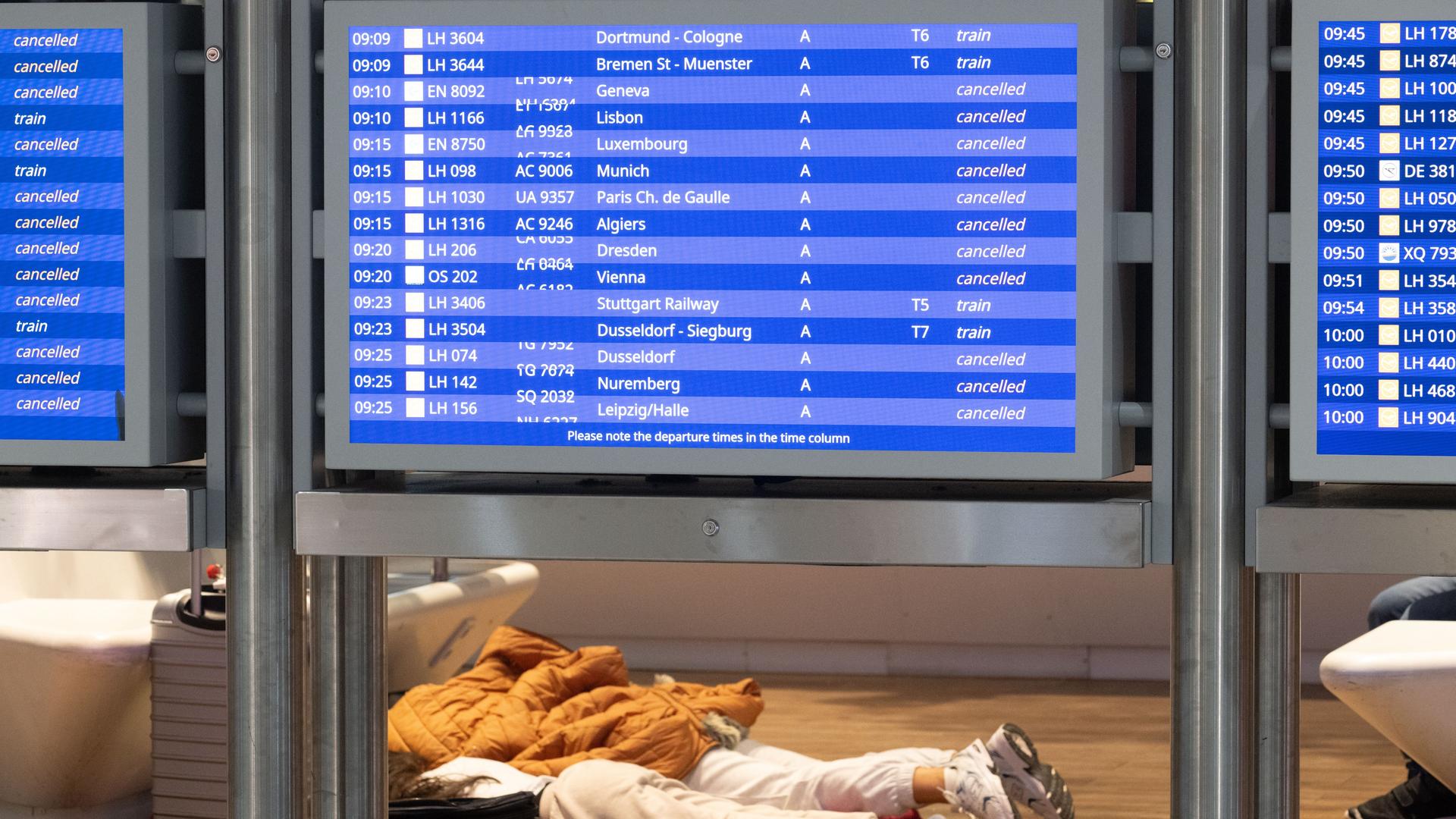 Gestrandete Passagiere schlafen neben ihren Koffern auf dem Flughafen Frankfurt. 