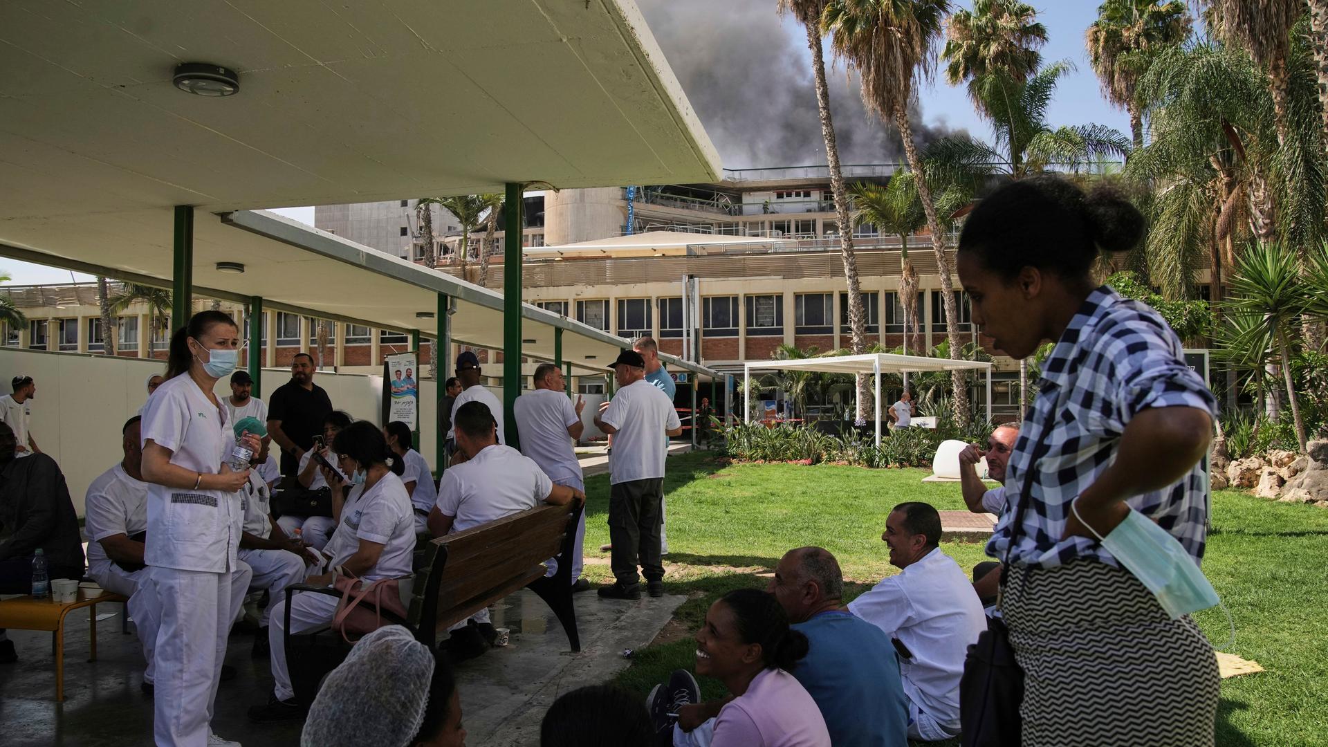 Krankenhauspersonal versammelt sich im Freien, während Rauch aus einem Gebäude des Soroka-Krankenhauses in Beerscheva aufsteigt, nachdem es von einer aus dem Iran abgefeuerten Rakete getroffen wurde. Krankenhauspersonal versammelt sich im Freien, während Rauch aus einem Gebäude des Soroka-Krankenhauses in Beerscheva aufsteigt, nachdem es von einer aus dem Iran abgefeuerten Rakete getroffen wurde.