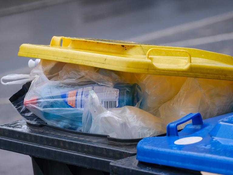 Eine überquellende "gelbe Tonne" mit Plastikmüll. 