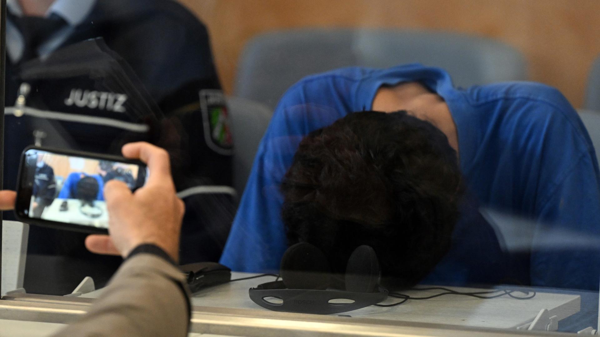 Düsseldorf: Der Angeklagte im Gerichtssaal der Oberlandesgerichts. Er hat den Kopf auf den Tisch gelegt, damit man sein Gesicht nicht sieht. Düsseldorf: Der Angeklagte im Gerichtssaal der Oberlandesgerichts. Er hat den Kopf auf den Tisch gelegt, damit man sein Gesicht nicht sieht.