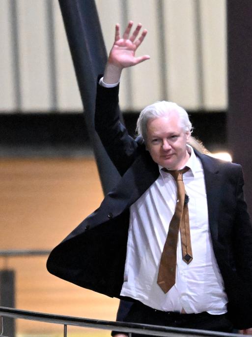 Wikileaks-Gründer Julian Assange winkt Unterstützern zu, nachdem er am Flughafen Canberra am 26. Juni 2024 angekommen ist.