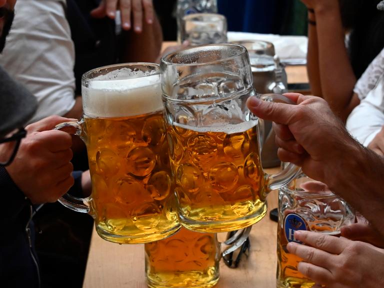 Zwei große, gefüllte Biergläser werden gegeneinander gestoßen.