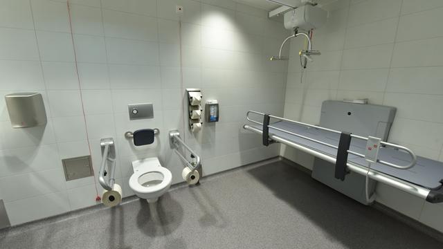 Eine große Behinderten-Toilette mit einer Liegge.