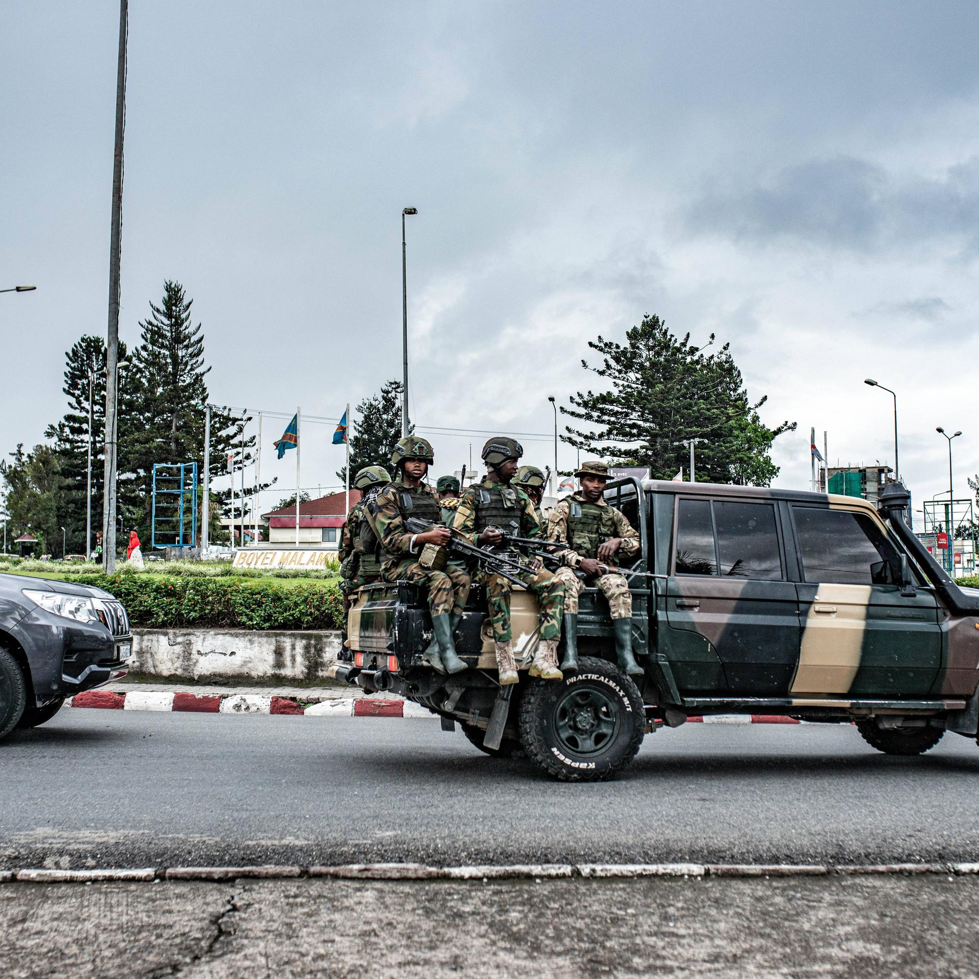 Soldaten der Miliz M23 sitzen auf der Ladefläche eines Pick-ups. Sie tragen Uniformen und Waffen. Sie fahren durch die Stadt Goma im Osten der Demokratischen Republik Kongo.