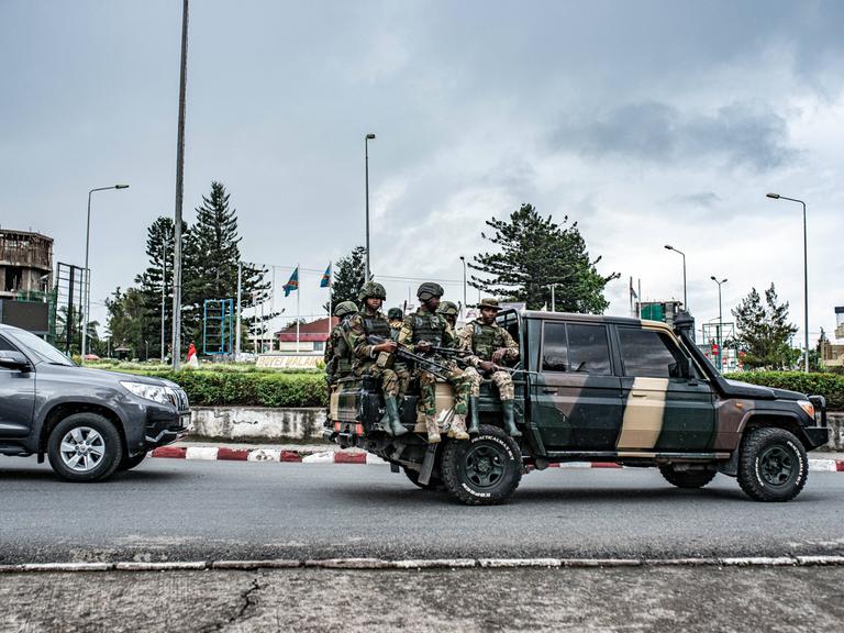 Soldaten der Miliz M23 sitzen auf der Ladefläche eines Pick-ups. Sie tragen Uniformen und Waffen. Sie fahren durch die Stadt Goma im Osten der Demokratischen Republik Kongo.