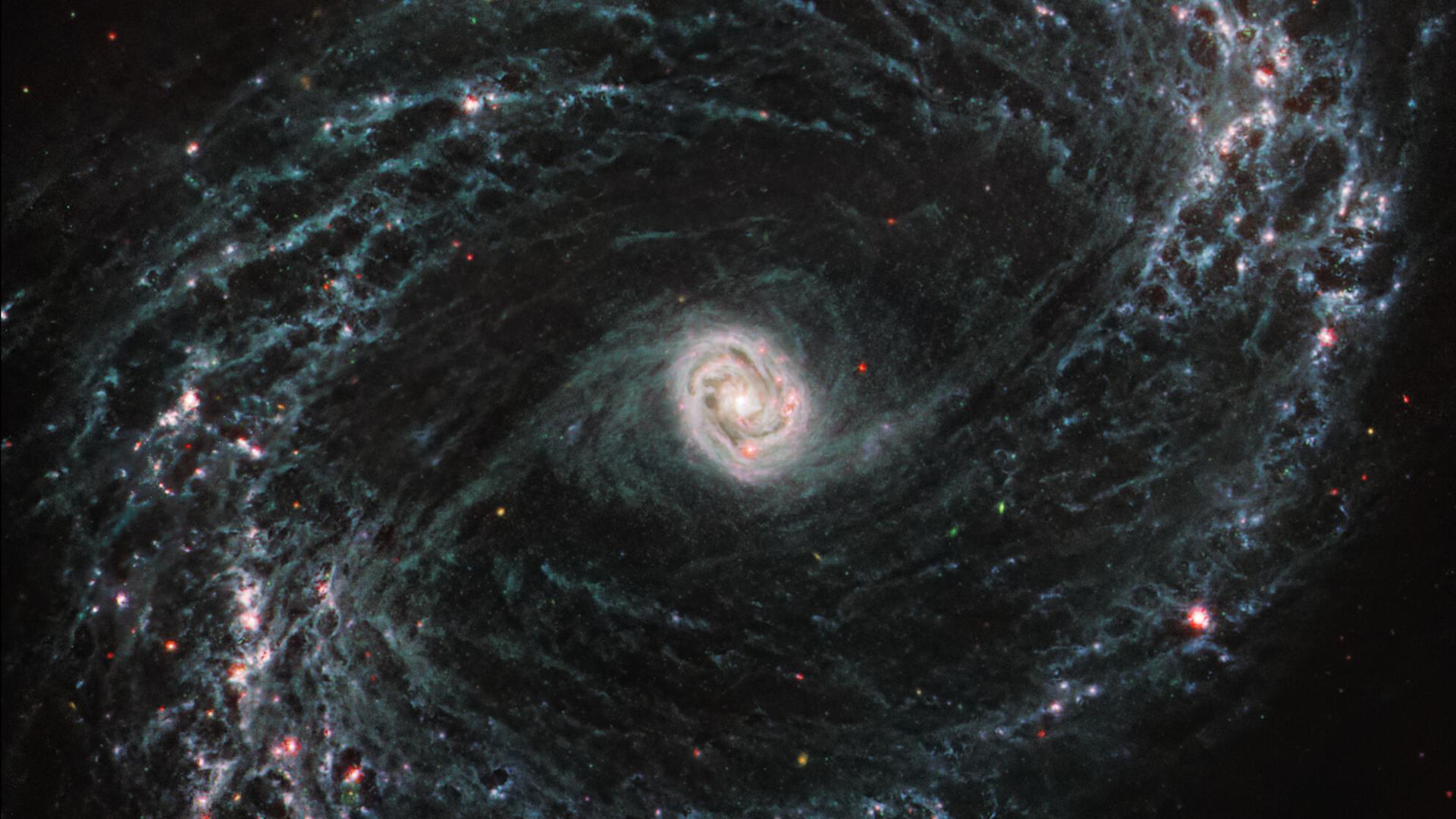 Detaillierte Aufnahme einer Spiralgalaxie, die vom James Webb Weltraumteleskop aufgenommen wurde. Die Galaxie hat einen hellen Kern, von dem sich spiralförmige Arme ausbreiten.