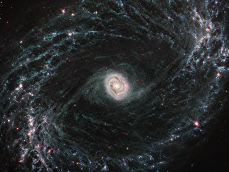 Detaillierte Aufnahme einer Spiralgalaxie, die vom James Webb Weltraumteleskop aufgenommen wurde. Die Galaxie hat einen hellen Kern, von dem sich spiralförmige Arme ausbreiten.