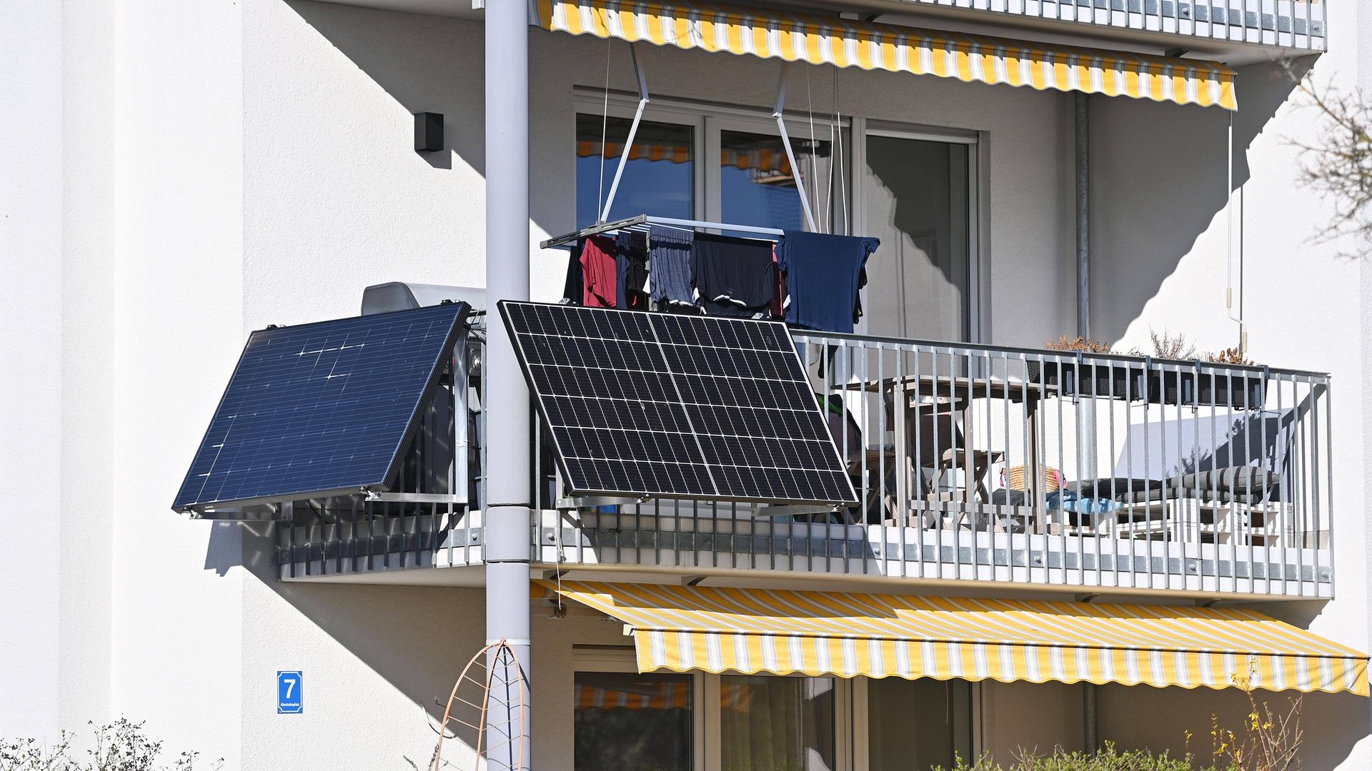Solarpanels an der Außenseite eines Balkons von einem Wohnblock in München. 