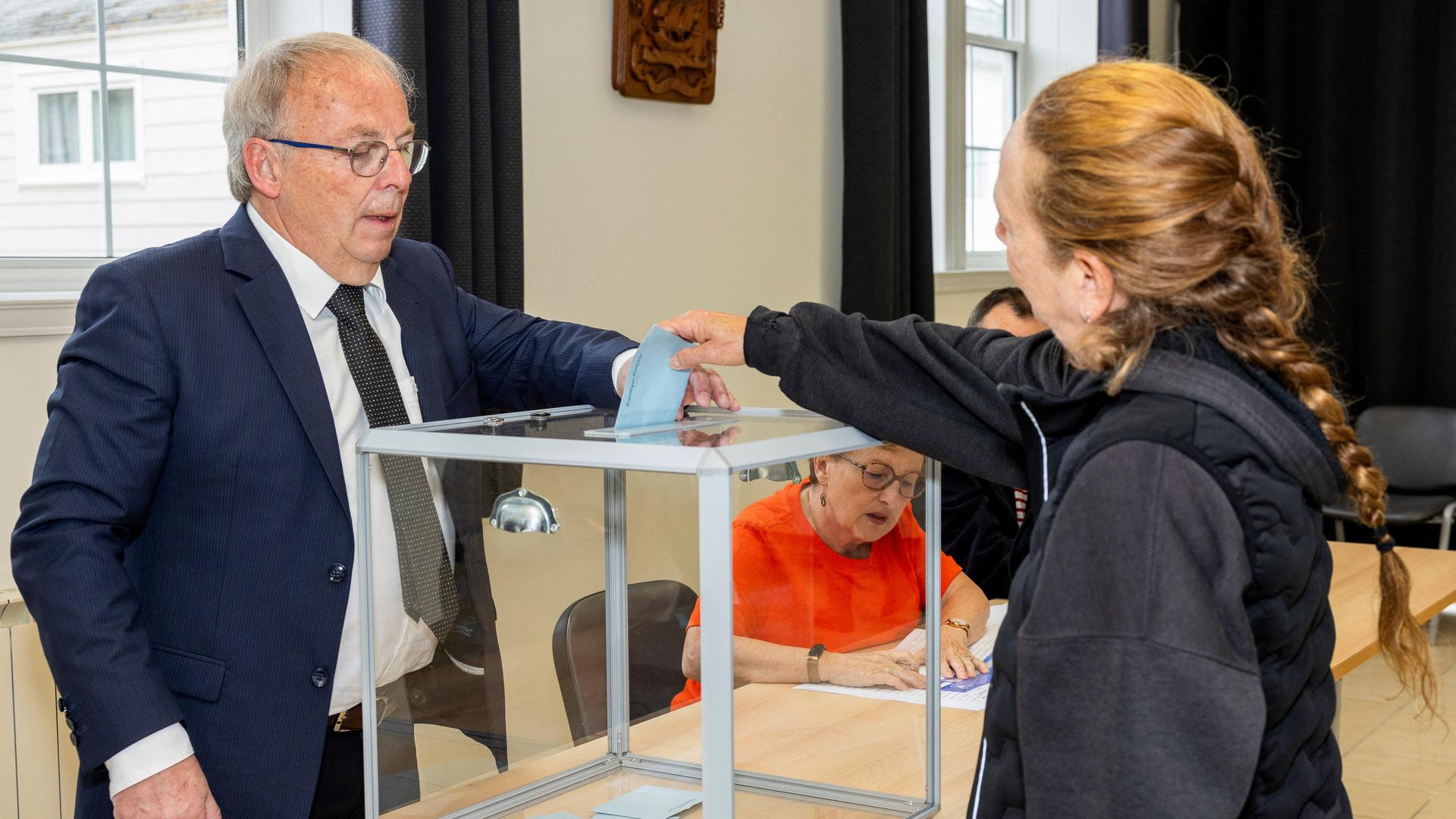 Eine Frau wirft ihren Stimmzettel in eine Wahlurne. Eine Frau wirft ihren Stimmzettel in eine Wahlurne.