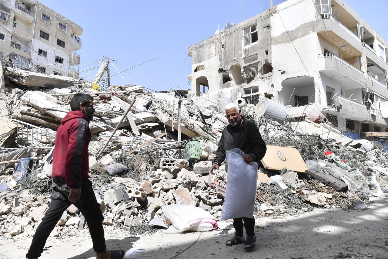 Zwei Männer vor einem eingestürzten Gebäude nach einem israelische Angriff auf die Stadt Tyros im Südlibanon, 17. Mai 2026 