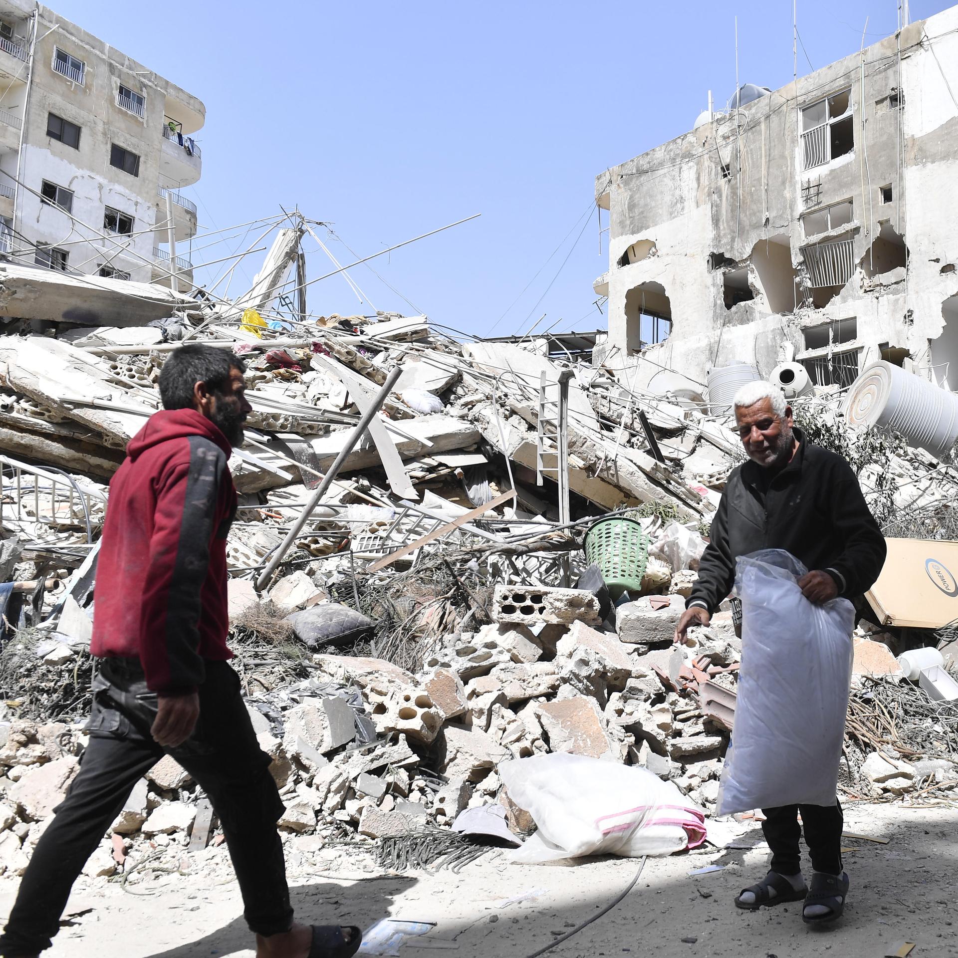 Zwei Männer vor einem eingestürzten Gebäude nach einem israelische Angriff auf die Stadt Tyros im Südlibanon, 17. Mai 2026 