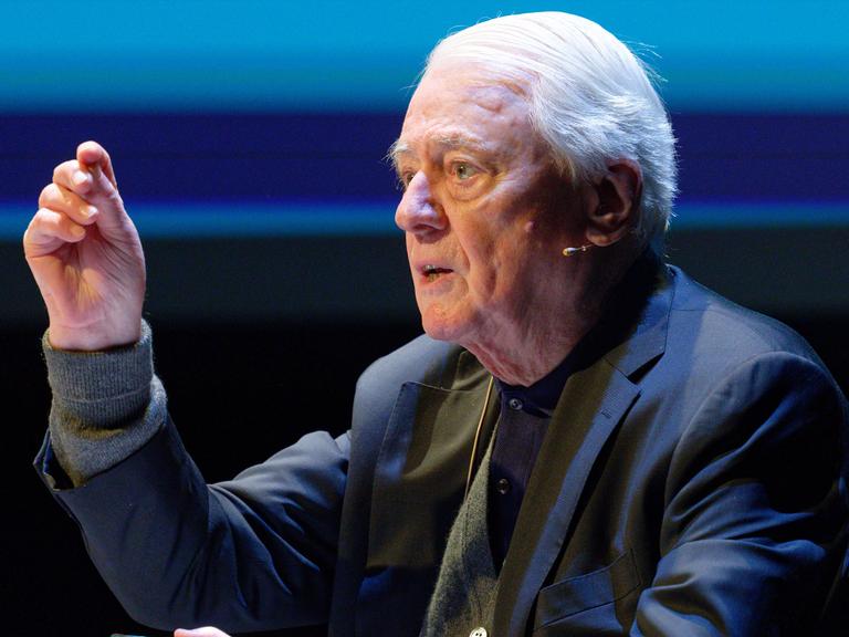 Alexander Kluge diskutiert auf einer Veranstaltung.