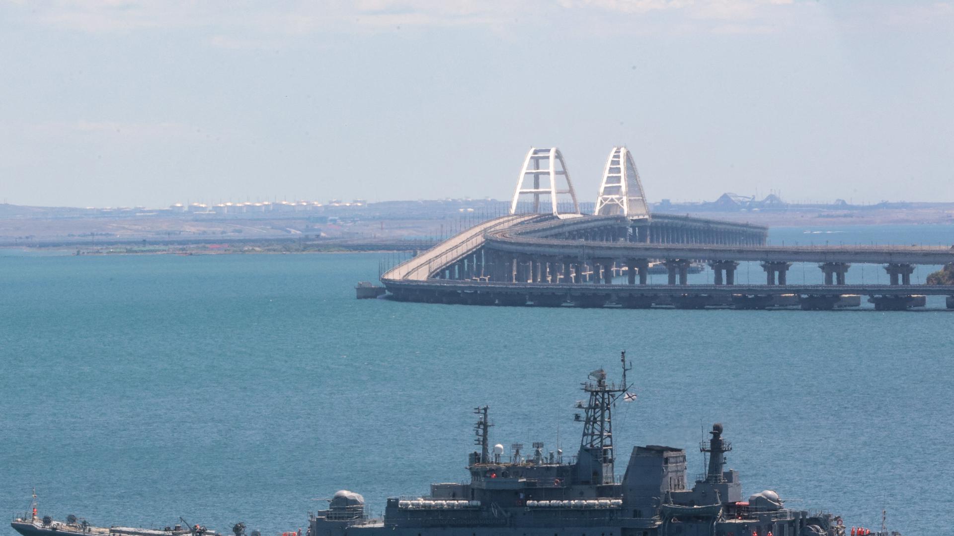 Die Brücke von Kertsch vor der Halbinsel Krim. Im Vordergrund ist ein russisches Kriegsschiff zu sehen. Die Brücke von Kertsch vor der Halbinsel Krim. Im Vordergrund ist ein russisches Kriegsschiff zu sehen.