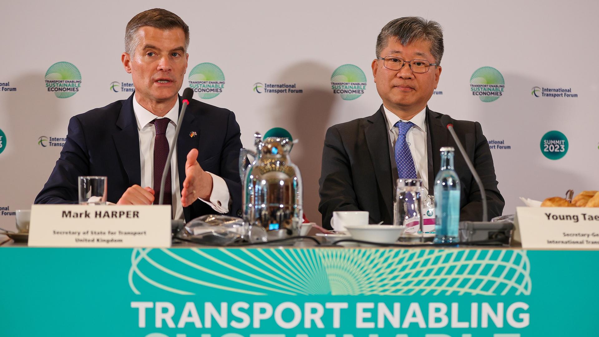 Sachsen, Leipzig: Mark Harper (l), Verkehrsminister von Großbritannien, und Young Tae Kim, Generalsekretär des Weltverkehrsforums, sitzen zur Eröffnung des Weltgipfels der Verkehrsminister auf einem Podium.
