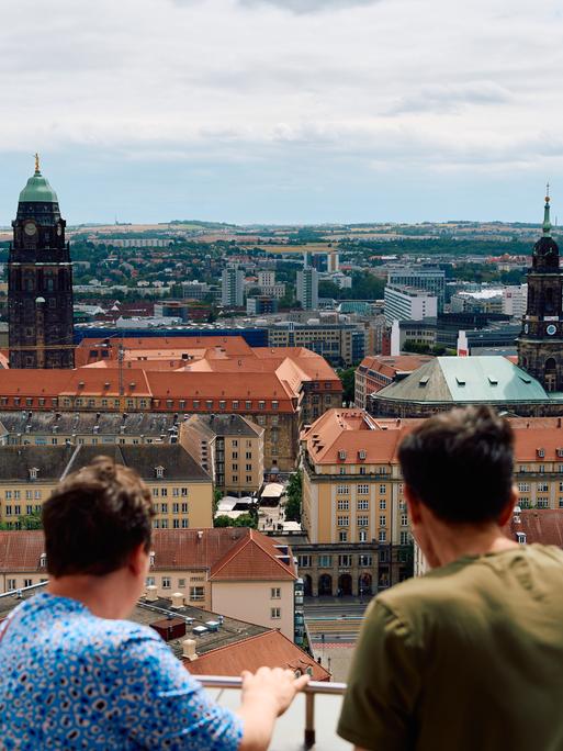 Menschen schauen von oben von der Frauenkirche aus auf die Dresdner Innenstadt