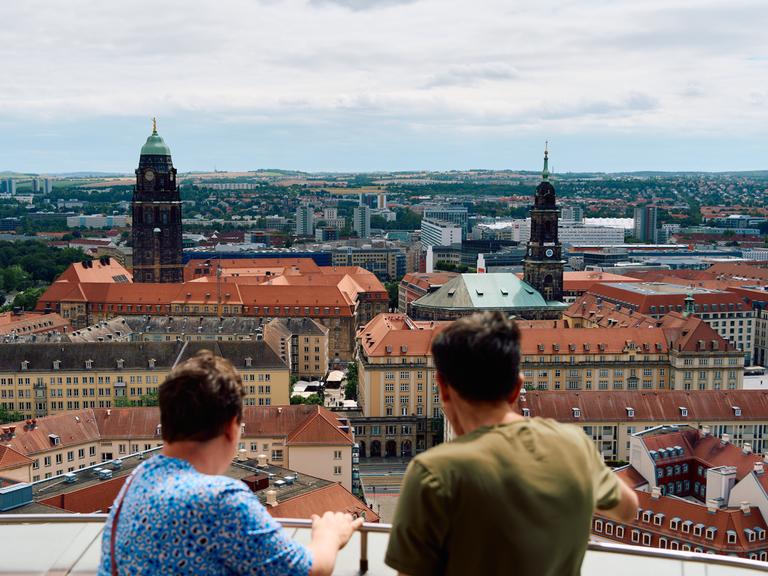 Menschen schauen von oben von der Frauenkirche aus auf die Dresdner Innenstadt