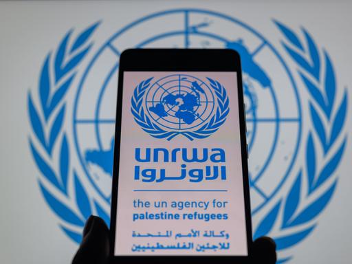 Das Logo des UN-Palästinenser-Hilfswerks UNRWA ist auf einem Handy zu sehen.