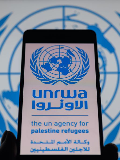 Das Logo des UN-Palästinenser-Hilfswerks UNRWA ist auf einem Handy zu sehen.