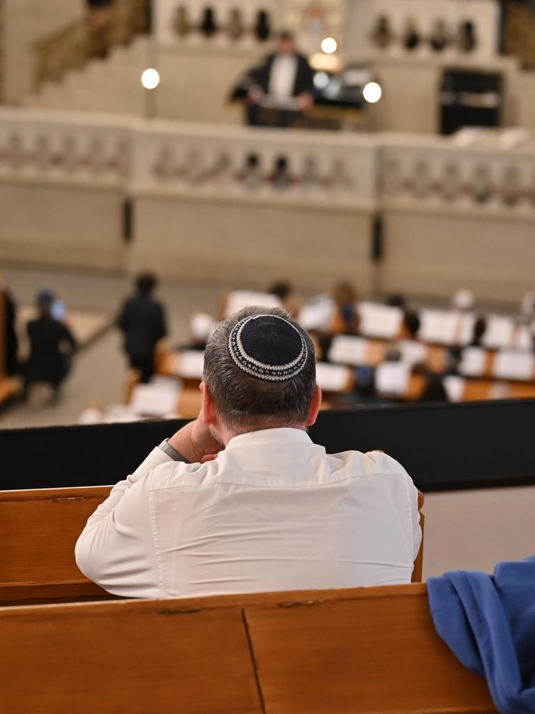 Ein Mann mit Kippa sitzt auf der Empore der Synagoge Rykestraße in Berlin und schaut hinunter auf eine Ordinationszeremonie.
