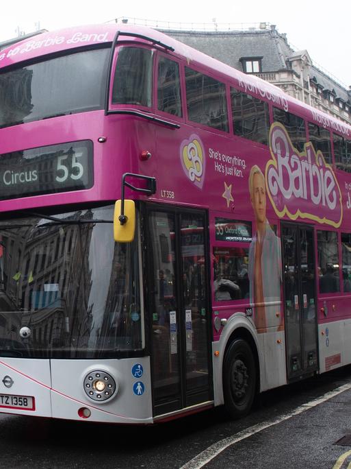 Ein Doppeldecker-Bus in London mit Werbung für den Film "Barbie" in pink. 