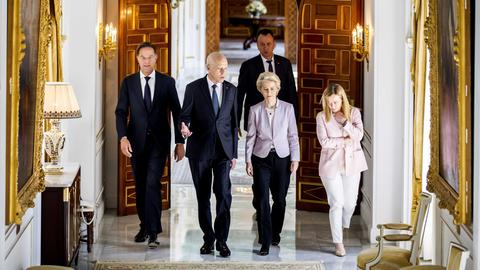 EU-Kommisionspräsidentin von der Leyen (2.v.r) besucht zusammen mit dem niederländischen Ministerpräsidenten Rutte (ganz links) und der Ministerpräsidentin von Italien, Meloni, den tunesischen Präsidenten Saied. Sie laufen durch die Residenz. Auf beiden Seiten des Ganges hängen Spigel in Goldrahmen.