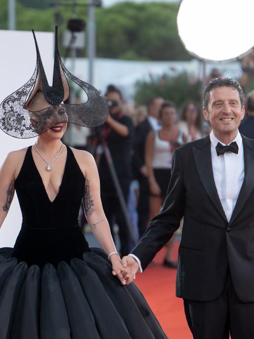 Der umstrittene rechte Festival-Präsident Pietrangelo Buttafuoco (r) mit dem Künstlerischen Leiter Alberto Barbera und Lady Gaga auf dem roten Teppich in Venedig.    