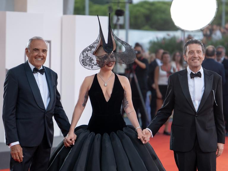 Der umstrittene rechte Festival-Präsident Pietrangelo Buttafuoco (r) mit dem Künstlerischen Leiter Alberto Barbera und Lady Gaga auf dem roten Teppich in Venedig.    