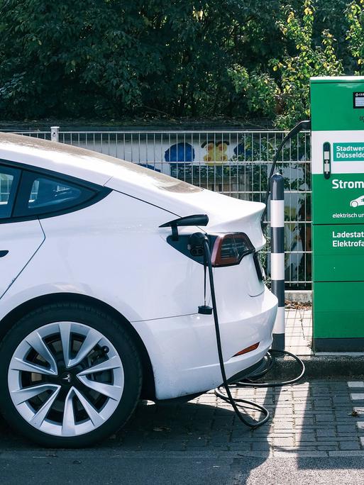 Ein E-Auto steht an einer Stromtankstelle