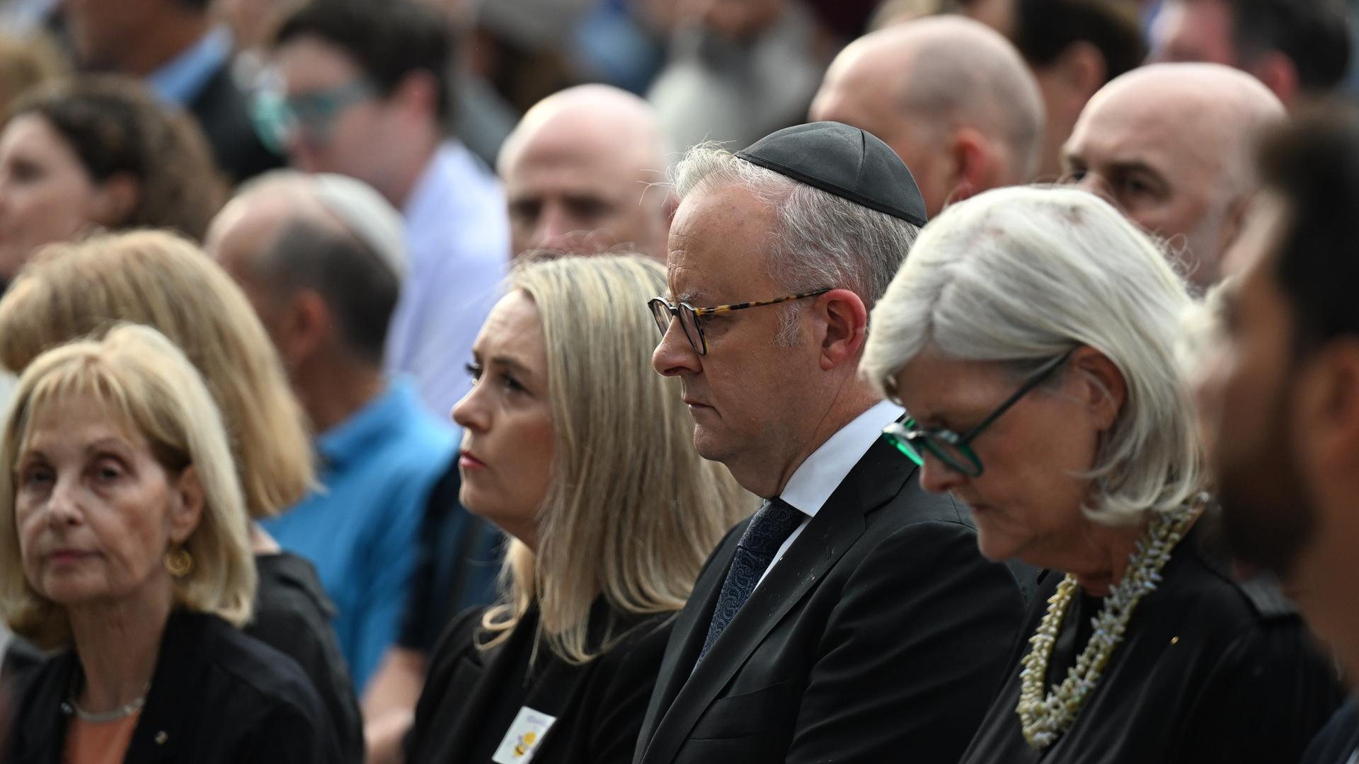 Der australische Premierminister Anthony Albanese (M) mit seiner Frau Jodie Haydon (l) und Generalgouverneurin Sam Mostyn (r) während der Schweigeminute anlässlich des nationalen Gedenktages für die Opfer und Überlebenden des Anschlags am Bondi Beach.