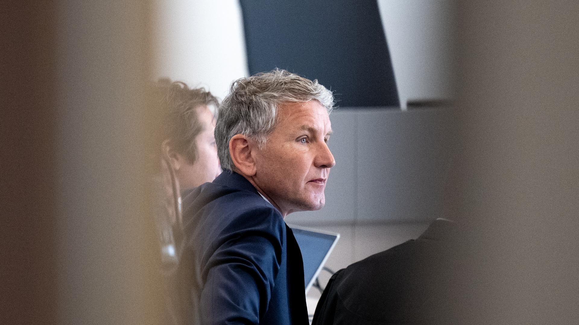 Björn Höcke, Vorsitzender der Thüringer AfD, ist in einer Verhandlungspause durch die geöffnete Tür des Gerichtssaals im Landgericht zu sehen. 