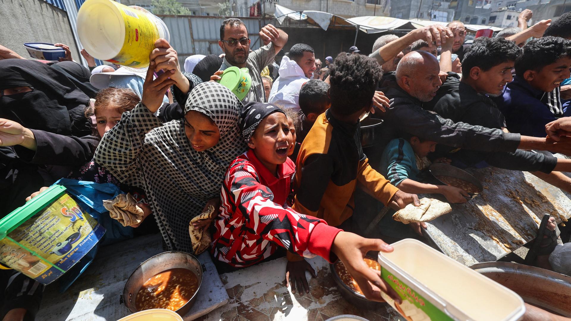 Palästinenser stehen für eine warme Mahlzeit in einer vom Welternährungsprogramm der Vereinten Nationen (WFP) betriebenen Küche im Flüchtlingslager Nuseirat im zentralen Gazastreifen an, 26. April 2025. Palästinenser stehen für eine warme Mahlzeit in einer vom Welternährungsprogramm der Vereinten Nationen (WFP) betriebenen Küche im Flüchtlingslager Nuseirat im zentralen Gazastreifen an, 26. April 2025.