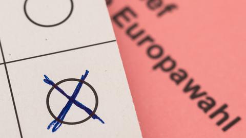 Ein Stimmzettel und ein Wahlbrief für die Briefwahl bei der Europawahl 2024 liegen auf einem Schreibtisch. 