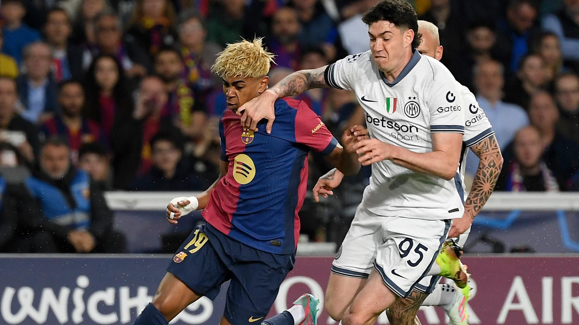 Szene aus dem Champions League-Spiel Barcelona gegen Inter Mailand; Lamine Yamal von Barcelona kämpft mit Alessandro Bastoni von Inter Mailand um den Ball.