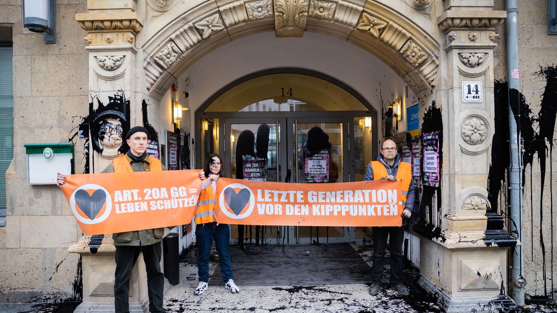Berlin: Aktivisten der Klimagruppe "Letze Generation" stehen mit Bannern vor der FDP-Bundesgeschäftsstelle nachdem diese mit ölartiger Farbe beschmiert wurde.