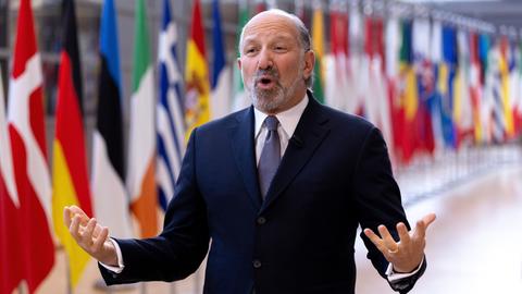 US-Handelsminister Howard Lutnick spricht und gestikuliert im Gebäude des Europäischen Rates in Brüssel. Hinter ihm sind die Flaggen der EU-Staaten. 