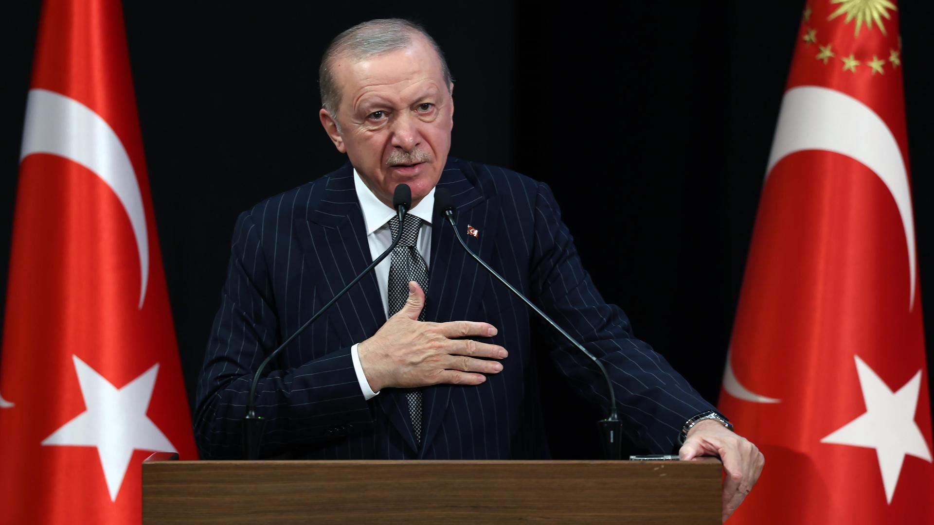 Der türkische Präsident Recep Tayyip Erdoğan an einem Rednerpult, links und rechts stehen türkische Flaggen. Der türkische Präsident Recep Tayyip Erdoğan an einem Rednerpult, links und rechts stehen türkische Flaggen.
