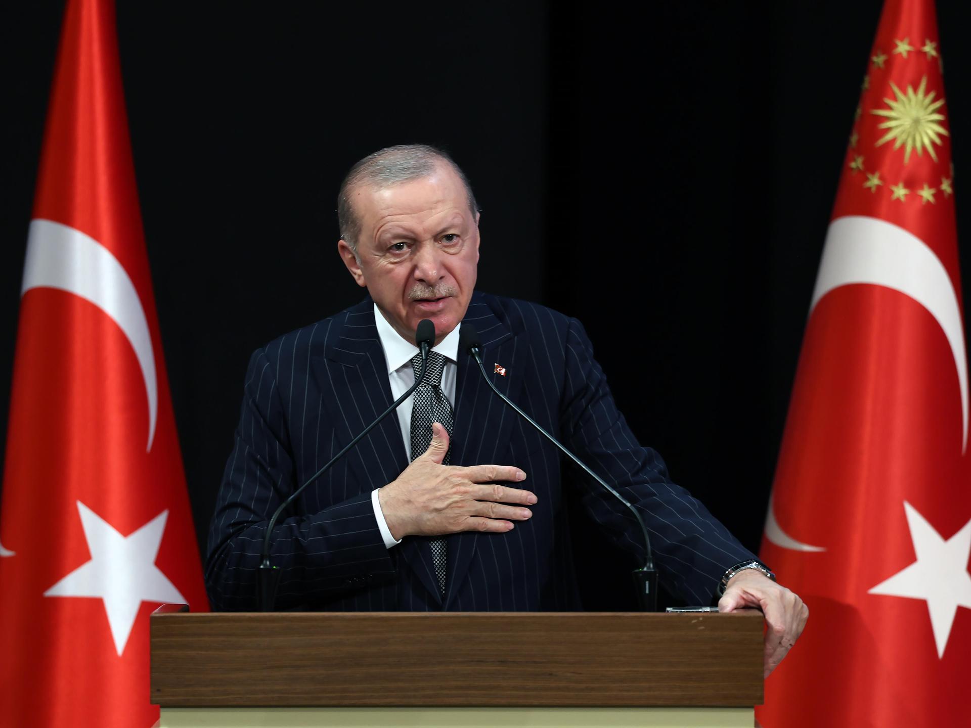 Der türkische Präsident Recep Tayyip Erdoğan an einem Rednerpult, links und rechts stehen türkische Flaggen.