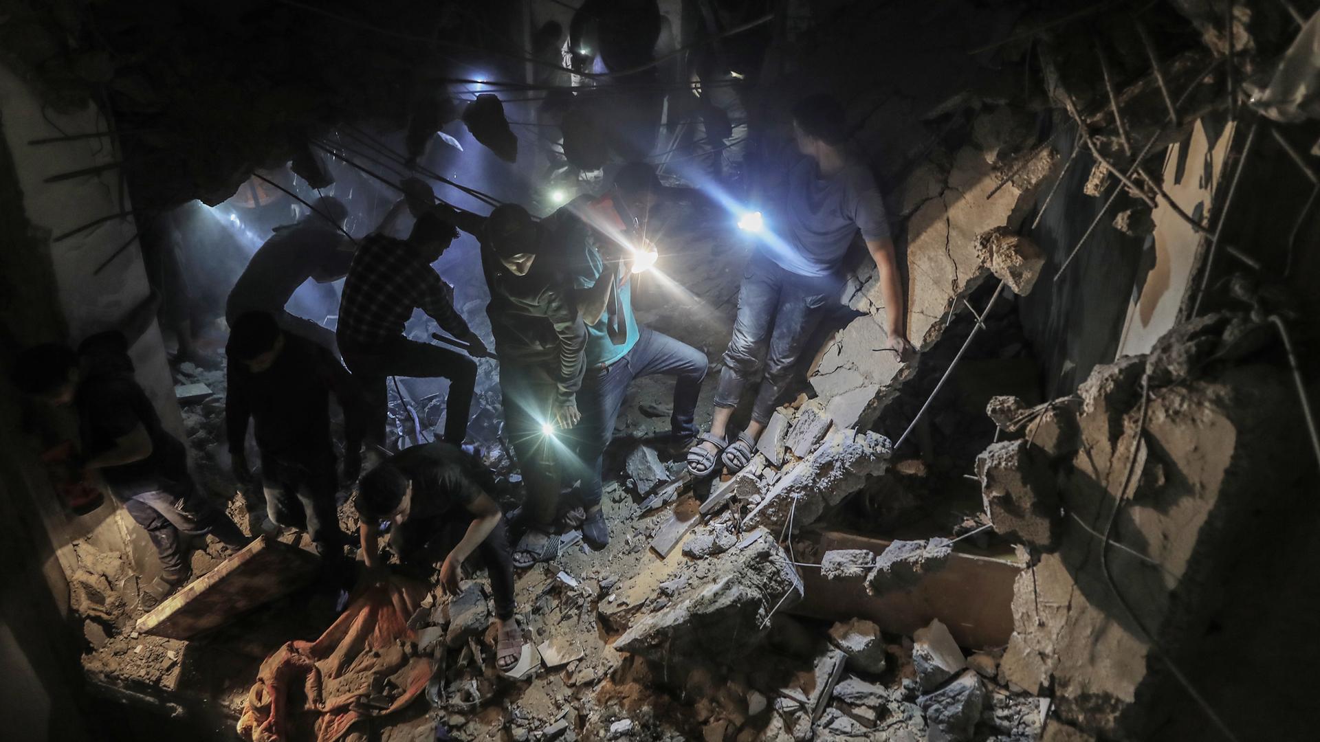 Such- und Rettungsmaßnahmen nach einem israelischer Angriff auf das Haus der Familie Ridwan am 20. April 2024 im Stadtteil Tel al-Sultan in Rafah, Gaza. Viele Palästinenser sind unter den Trümmern eingeschlossen und werden mit Taschenlampen gesucht.