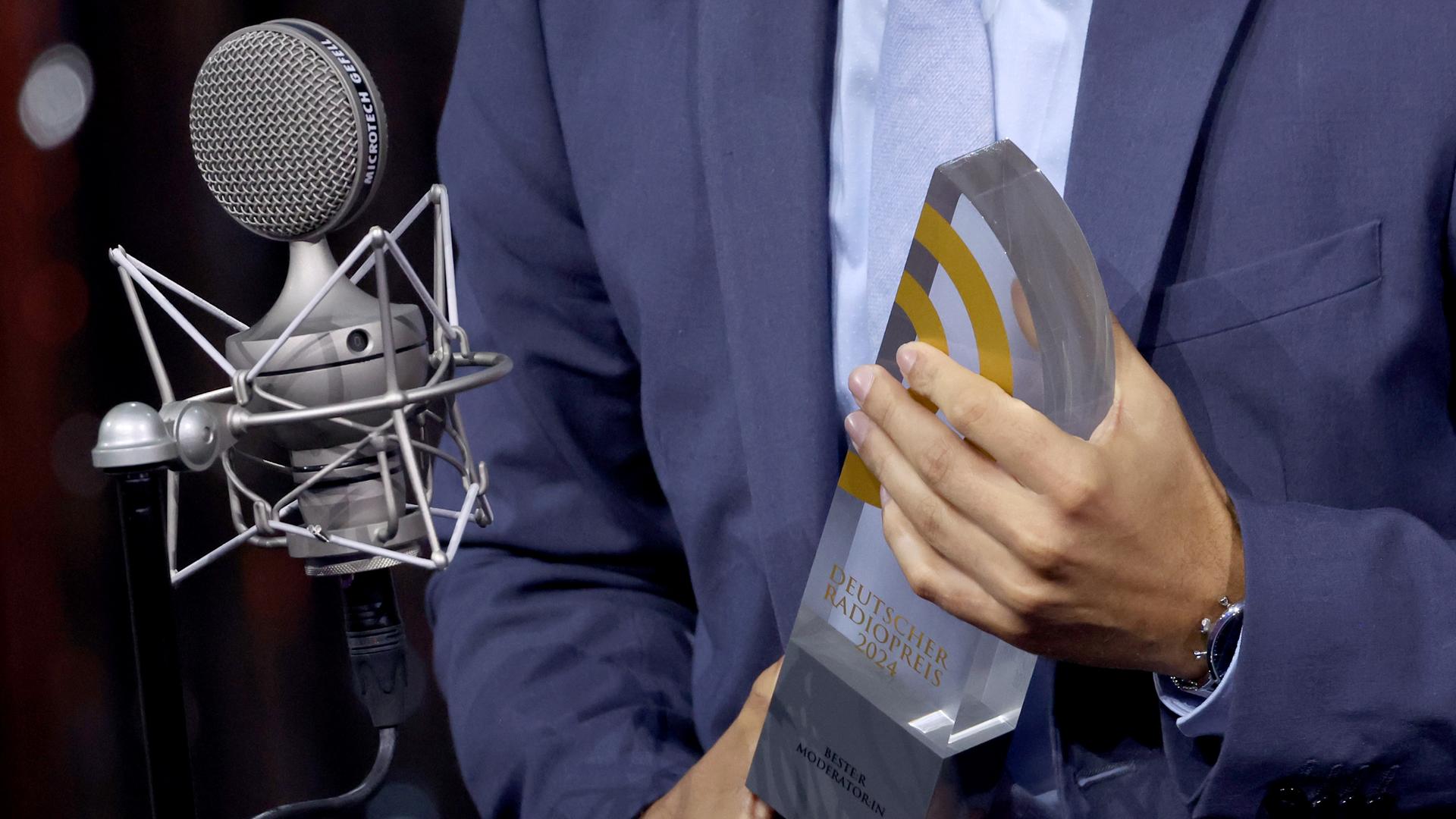 Der deutsche Radiopreis in den Händen von Gianluca Meli vom Sender 98.8 KISS FM.