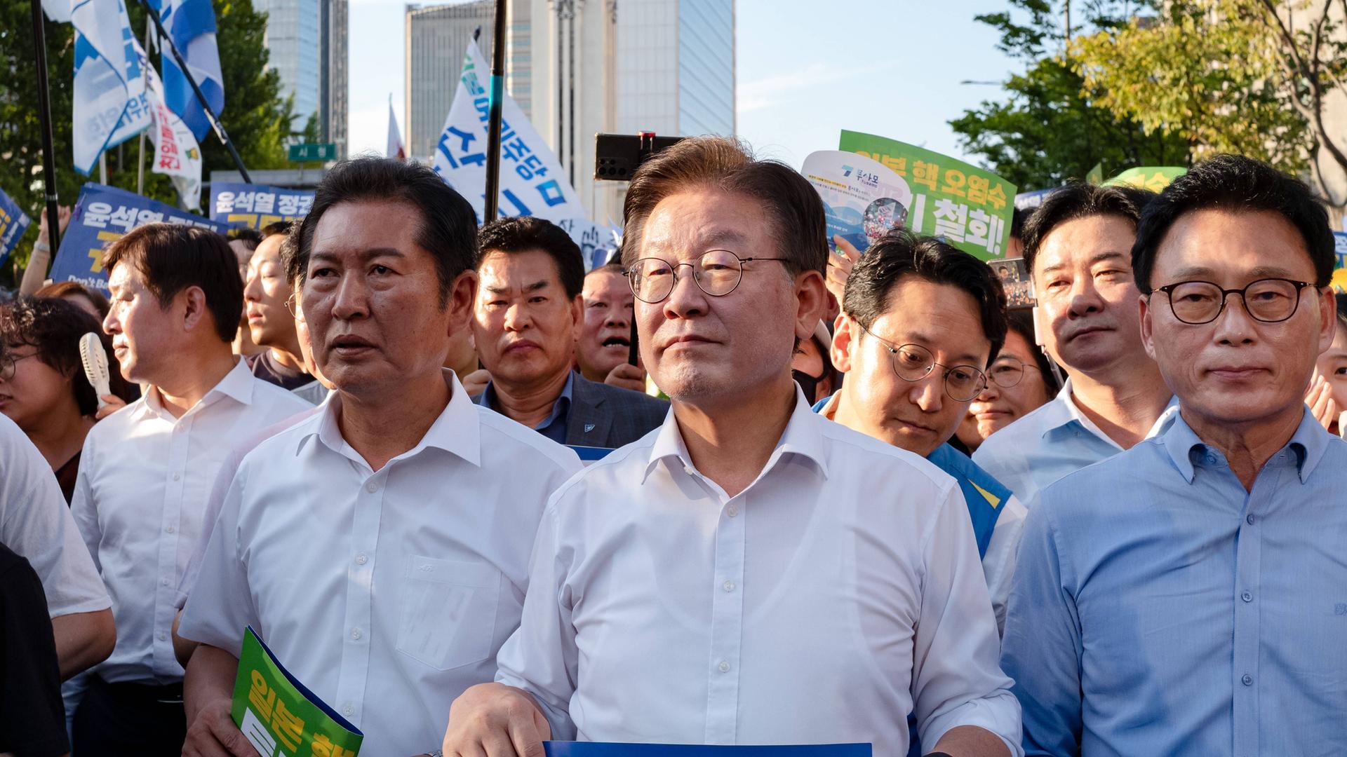 Das Bild zeigt Lee Jae-myung während einer Versammlung, um ihn herum stehen zahlreiche Menschen.
