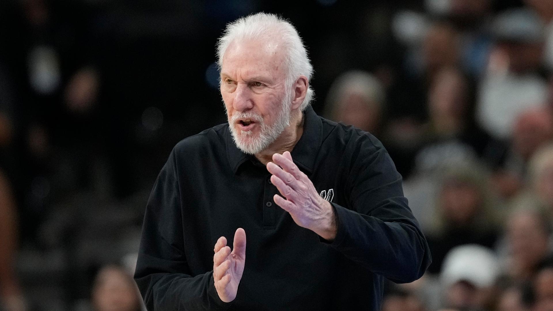 Gregg Popovich gestikuliert in einem schwarzen Sweatshirt während eines Spiels seiner Mannschaft