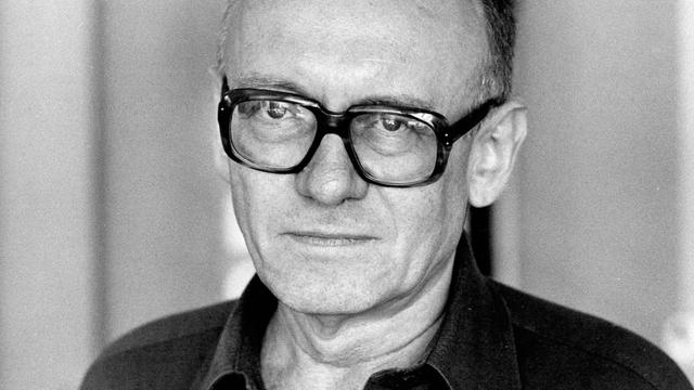 Schwarzweiß-Foto von Ernst Jandl, der ernst in die Kamera blickt