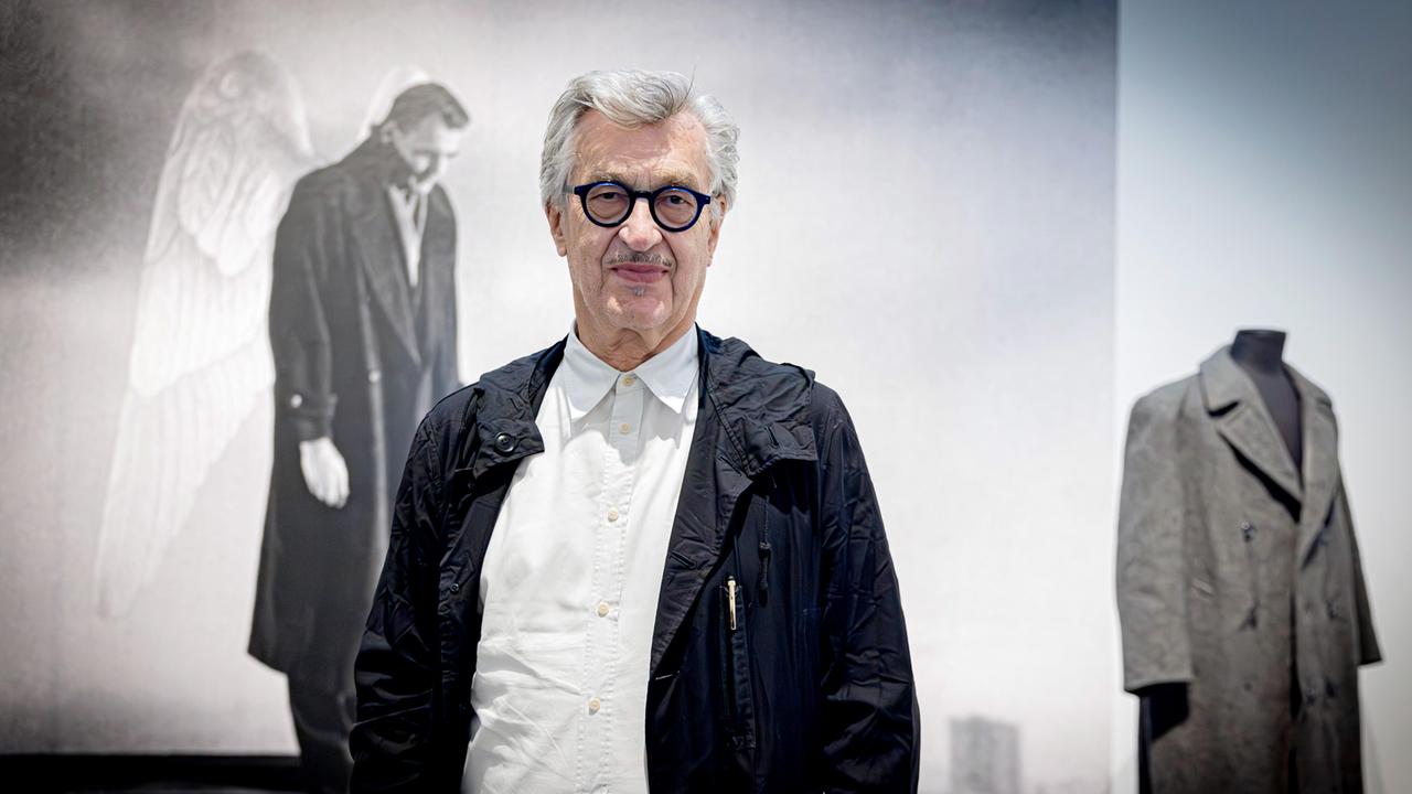 Wim Wenders in der Austellung vor Bild und Requisite von "Der Himmel über Berlin". 