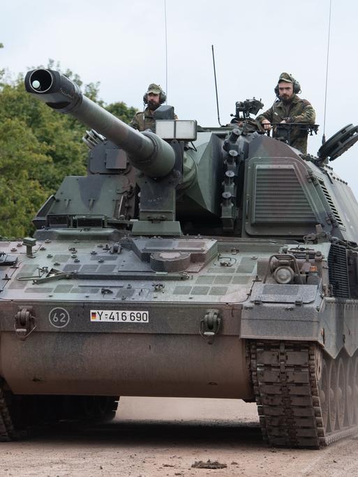 Zwei Soldaten fahren auf einem Panzer der Bundeswehr. 